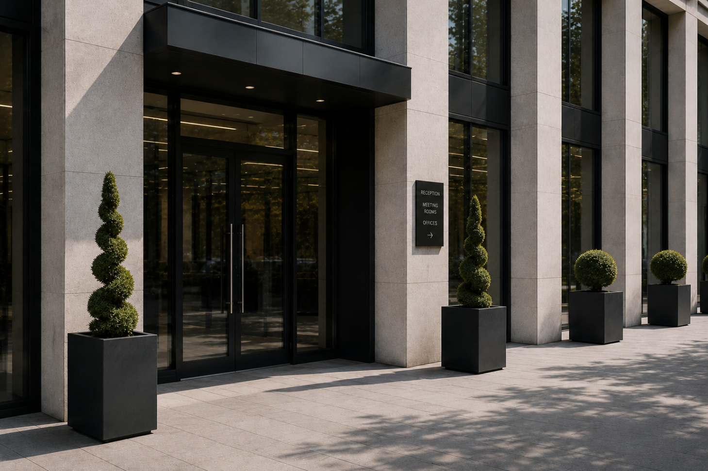 Commercial entrance with sculptural topiary in dark modern planters